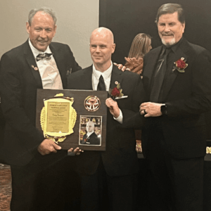 Shihan Craig Sargent, smiling as he receives the prestigious G.O.A.T. Award at a banquet.
